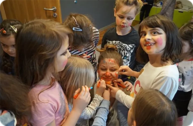 dzieci malują twarz lektorki na zajęciach