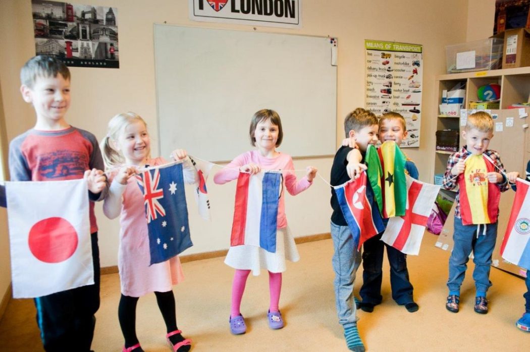 dzieci trzymają flagi różnych krajów