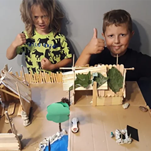 dzieci pokazują zrobioną makietę miasta